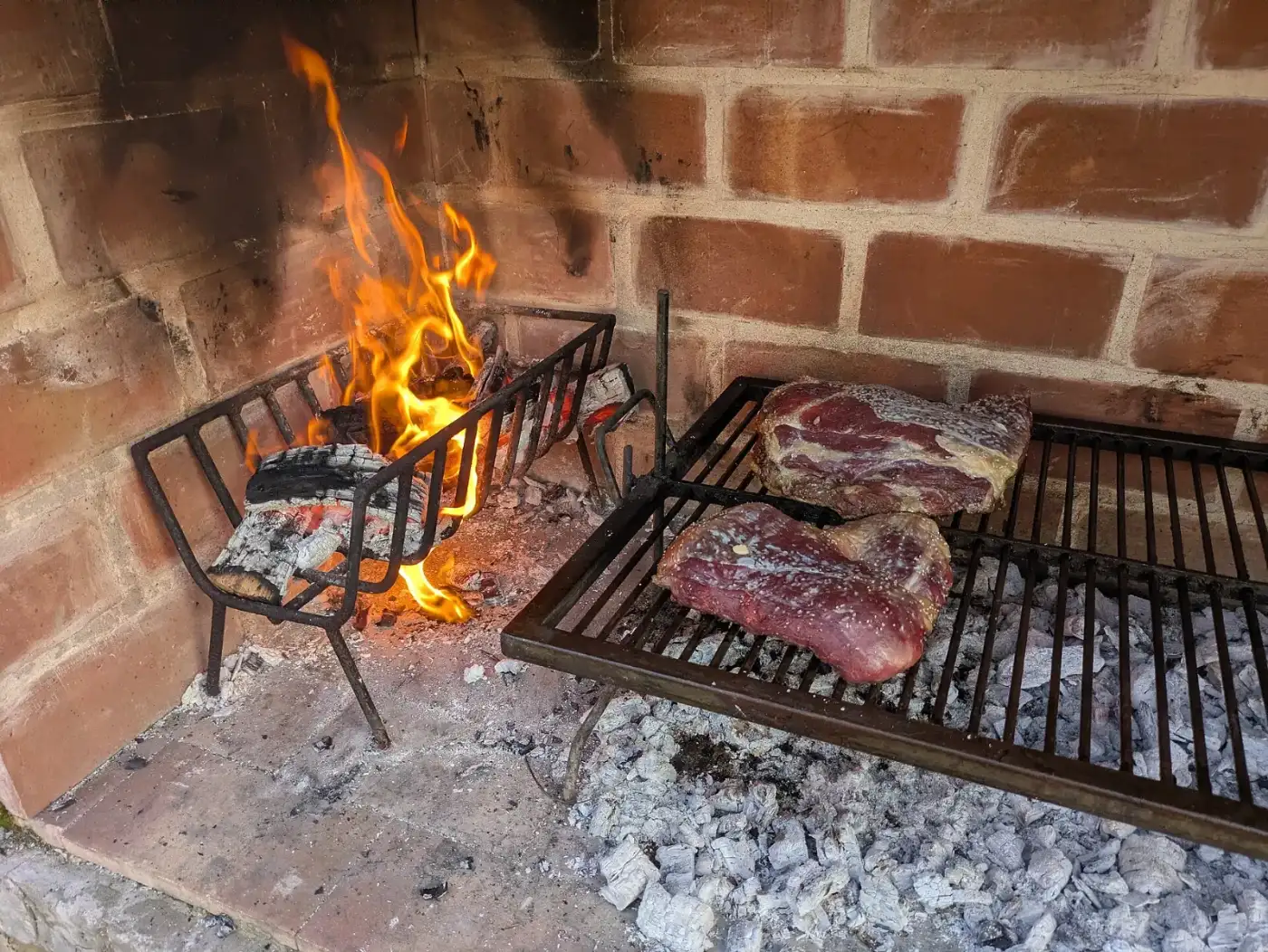 Carne sobre la parrilla junto a las brasas