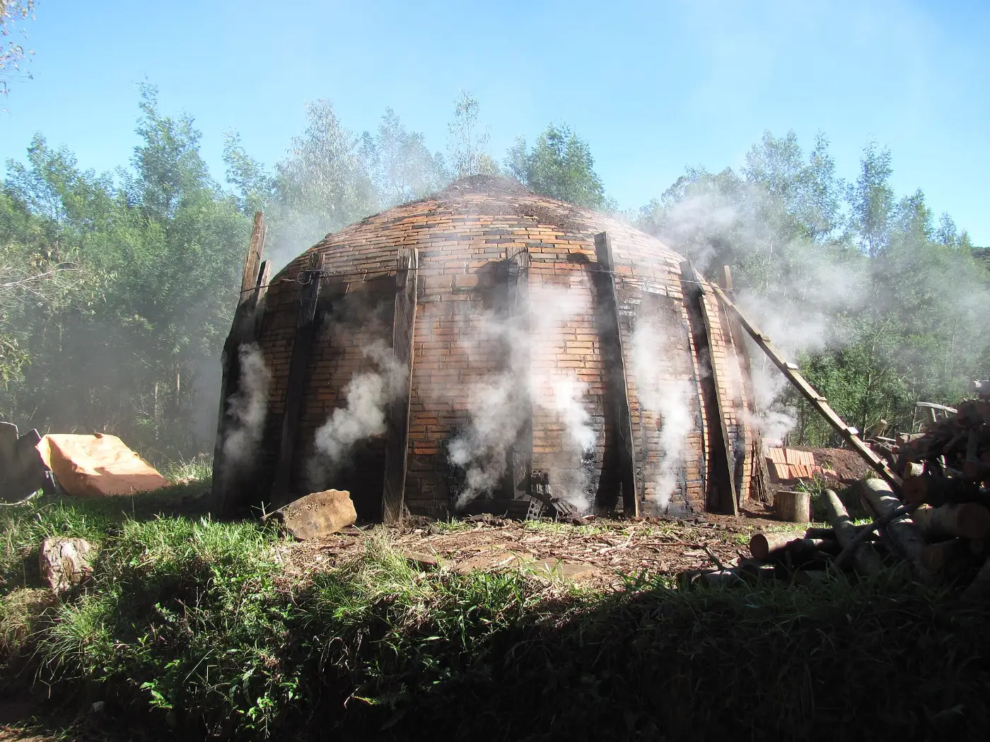 Horno de ladrillo humeando en plena carbonización