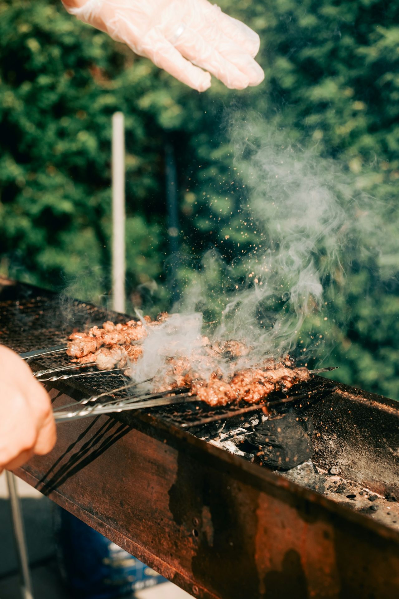 Chef asando carne sobre brasas de carbón en una cocina profesional